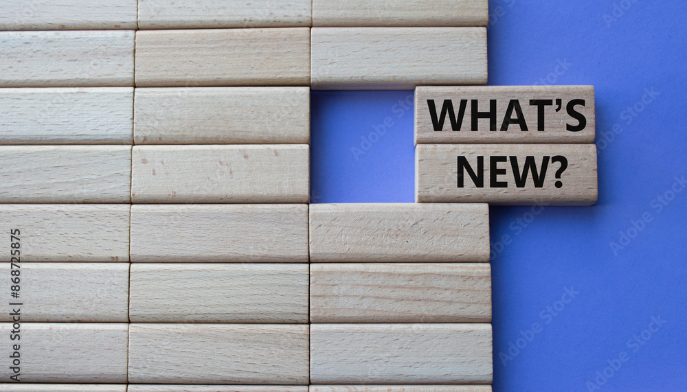 What is new symbol. Concept word What is new on wooden blocks. Beautiful purple background. Business and What is new concept. Copy space What is new symbol. Concept word What is new on wooden blocks. Beautiful purple background. Business and What is new concept. Copy space