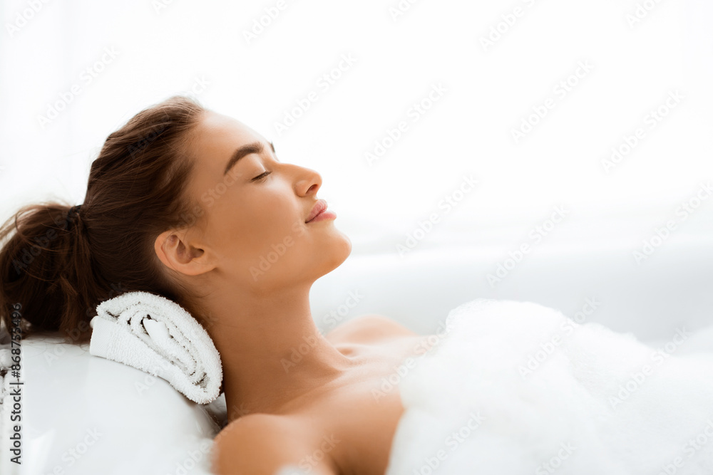 Woman enjoying pleasant bath with foam, lying with closed eyes, free space Woman enjoying pleasant bath with foam, lying with closed eyes, free space