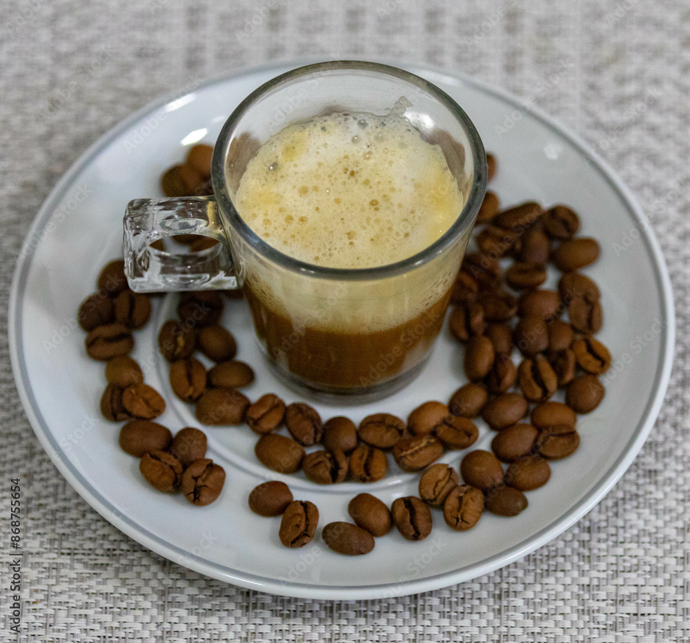 Espresso coffee served in a transparent cup with roasted coffee beans. Gourmet, 100% Arabica special Espresso coffee served in a transparent cup with roasted coffee beans. Gourmet, 100% Arabica special