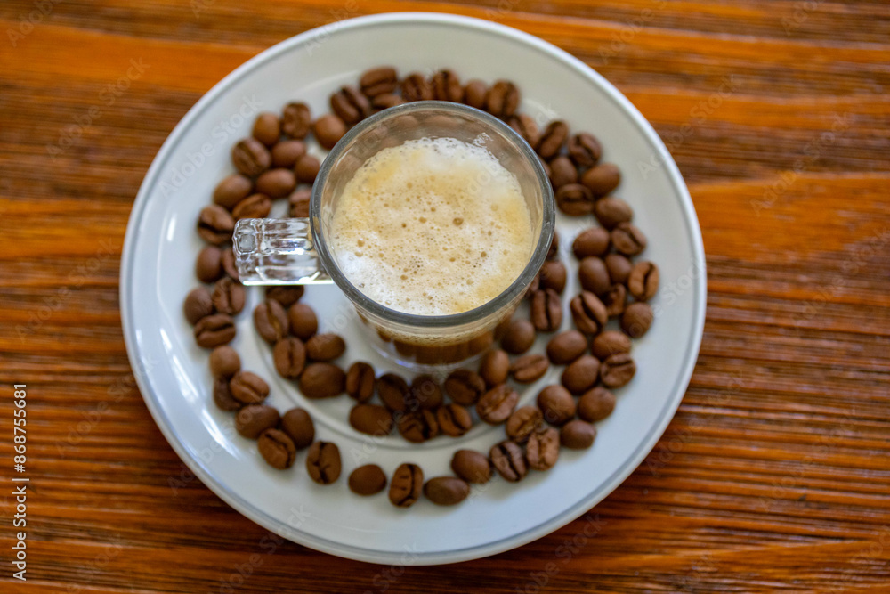 Espresso coffee served in a transparent cup with roasted coffee beans. Gourmet, 100% Arabica special Espresso coffee served in a transparent cup with roasted coffee beans. Gourmet, 100% Arabica special