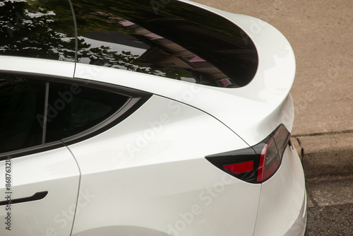 A white luxury EV parked on the street