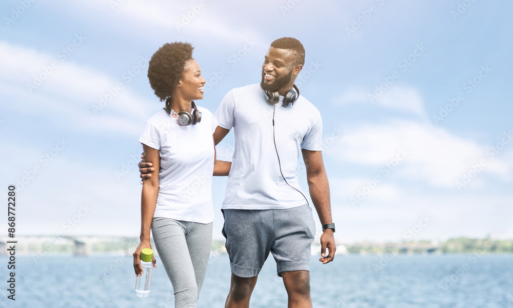 Sporty Afro Couple Hugging Walking Along River Embankment After Morning Jog. Free Space For Text Sporty Afro Couple Hugging Walking Along River Embankment After Morning Jog. Free Space For Text