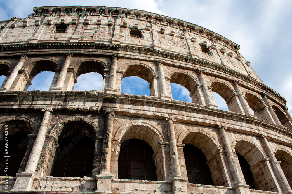 Fototapeta premium The famous Colosseum in Rome against the blue sky on a sunny May day