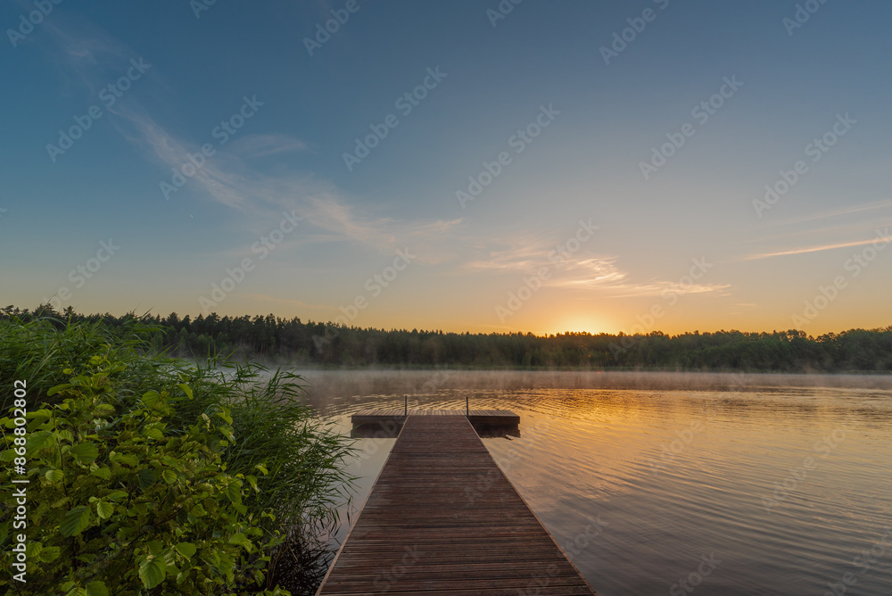 Fototapeta premium Small forest lake covered with fog at sunrise on June morning