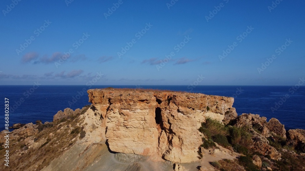 Flat rock formation Qarraba peninsula, close up on the cracked limestone where climbers can climb on the top. Ghajn Tuffieha , Qarraba peninsula, aerial close up. High quality photo Flat rock formation Qarraba peninsula, close up on the cracked limestone where climbers can climb on the top. Ghajn Tuffieha , Qarraba peninsula, aerial close up. High quality photo