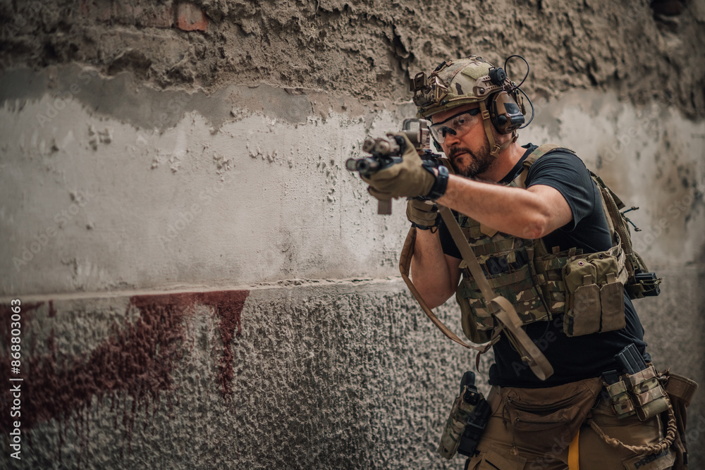 Fototapeta premium Portrait of soldier shot with sniper rifle at abandoned building.