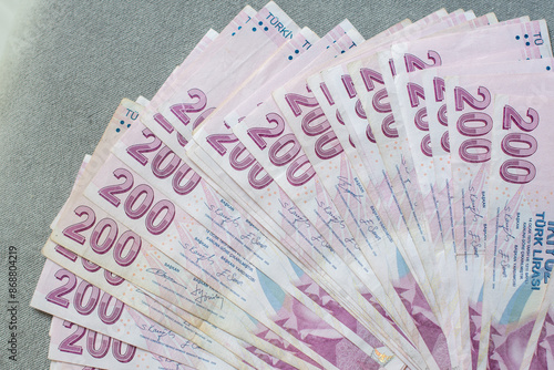 Tableau sur toile A thick stack of Turkish lira is laid out on a gray velvet table, ready to be co