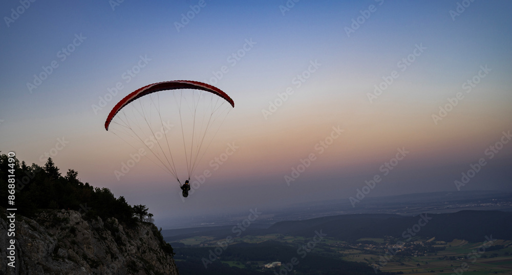 Paragliding concept, a paraglider pilot fly in the sky at sunset on the nature mountain landscape background. Paragliding concept, a paraglider pilot fly in the sky at sunset on the nature mountain landscape background.