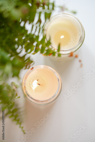 Enhance your home decor with burning candles and fern leaves for a relaxing and cozy ambiance