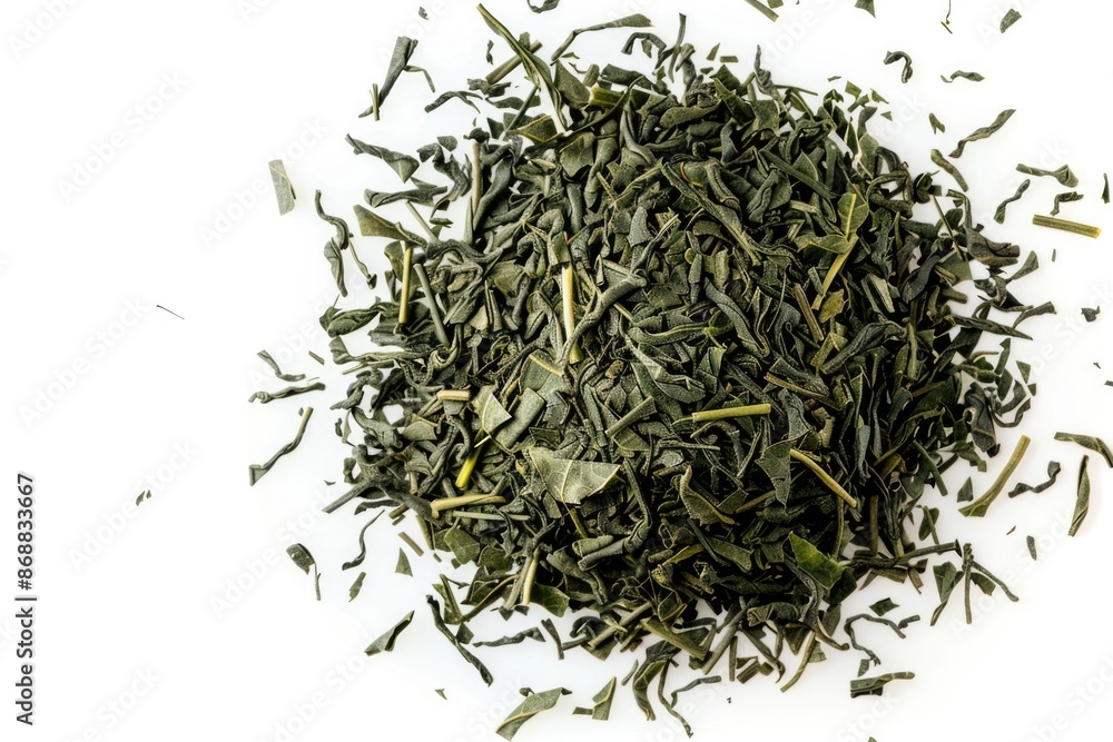 A pile of green tea leaves on a white surface A pile of green tea leaves on a white surface