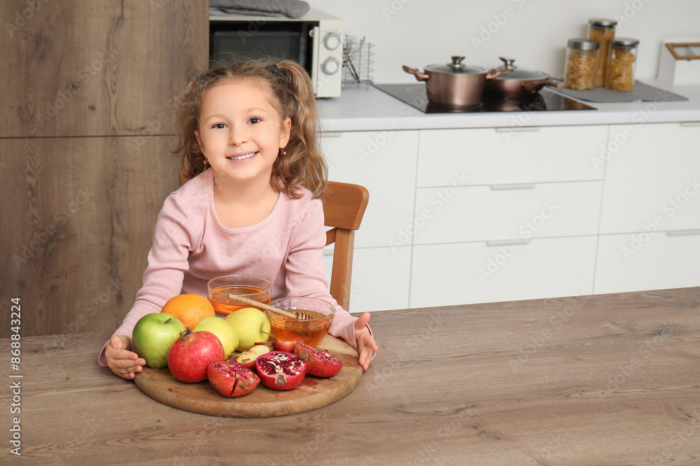Cute little girl with ripe fruits and honey in kitchen. Rosh Hashanah (Jewish New Year) celebration Cute little girl with ripe fruits and honey in kitchen. Rosh Hashanah (Jewish New Year) celebration