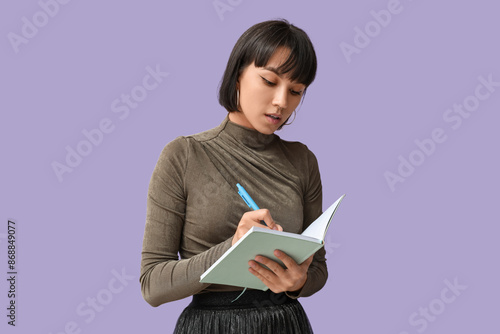 Pretty young woman writing ...