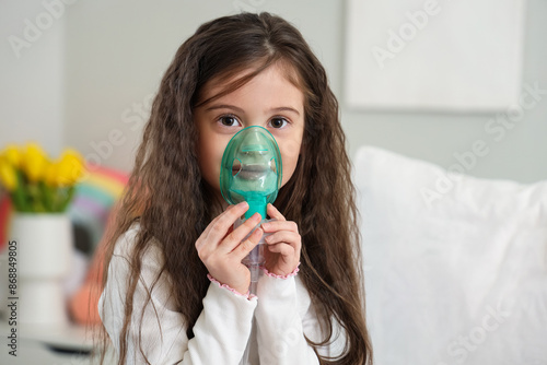 Little girl using nebulizer...