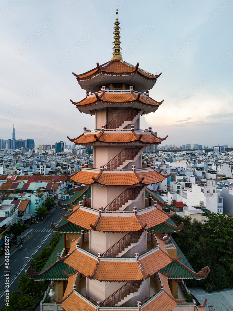 Φωτογραφία Buddhist temple or pagoda prayer tower in late afternoon light with city skyline and urban sprawl of Ho Chi Minh City, Vietnam in the background