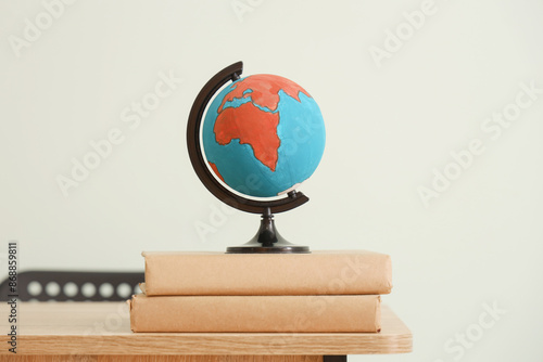 Globe with books on desk ag...