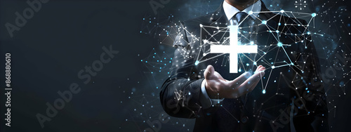 Businessman holding a glowing digital cross symbol with network connections, representing technology and innovation in business.