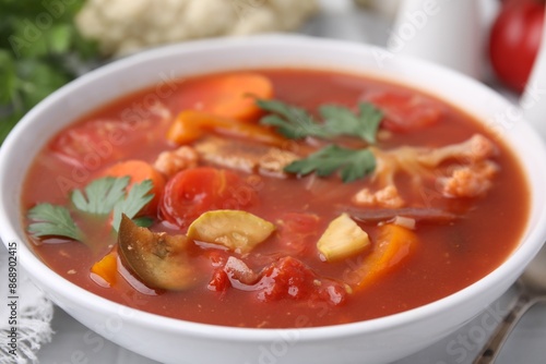 Delicious homemade stew in bowl on white table, closeup