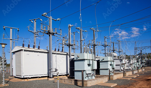 Electrical substations, Pylons and wires distribute power through high-voltage transmission lines. Blue Sky. Queensland, Australia.