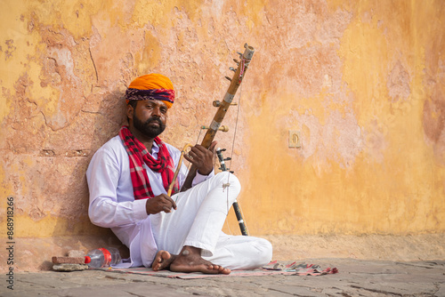 Picture of a Rajasthani artist playing violin on street. Jaipur, Pushkar, Jodhpur, Jaisalmer, desert, forts, sight seeing, tourism, attractive, music, tune, fine, string, wind, stick, wood, practice.
