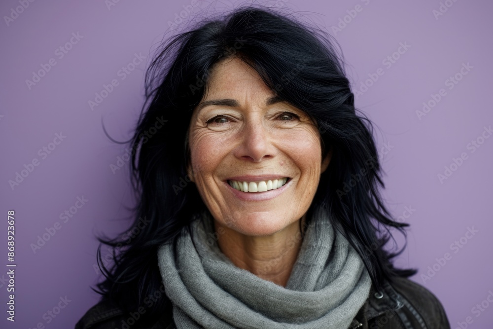 Portrait of a beautiful middle aged woman smiling against a purple background Portrait of a beautiful middle aged woman smiling against a purple background
