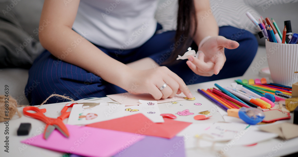 Selective focus, Hands of Young Asian woman sitting on sofa decorating a greeting card in the living room, Holiday hobbies, crafts, DIY cards Selective focus, Hands of Young Asian woman sitting on sofa decorating a greeting card in the living room, Holiday hobbies, crafts, DIY cards