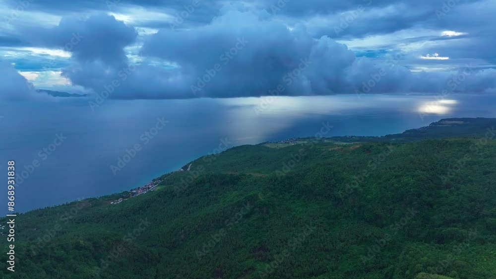 Dramatic cloudscape over sea of and green island in Biliran Island, Philippines. Aerial backwards shot. Dramatic cloudscape over sea of and green island in Biliran Island, Philippines. Aerial backwards shot.