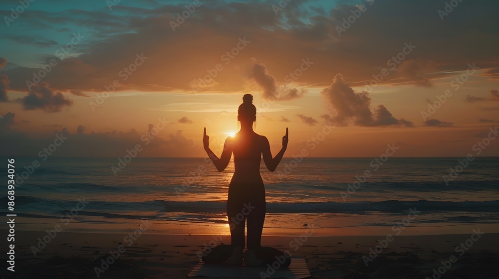 Fototapeta premium Silhouette young woman practicing yoga on the beach at sunrise. 