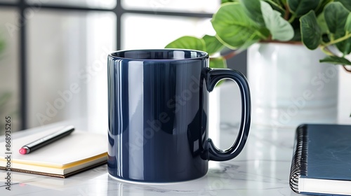 Navy blue mug arranged on a white marble countertop with notepad and decorative plant, ideal for elegant designs.