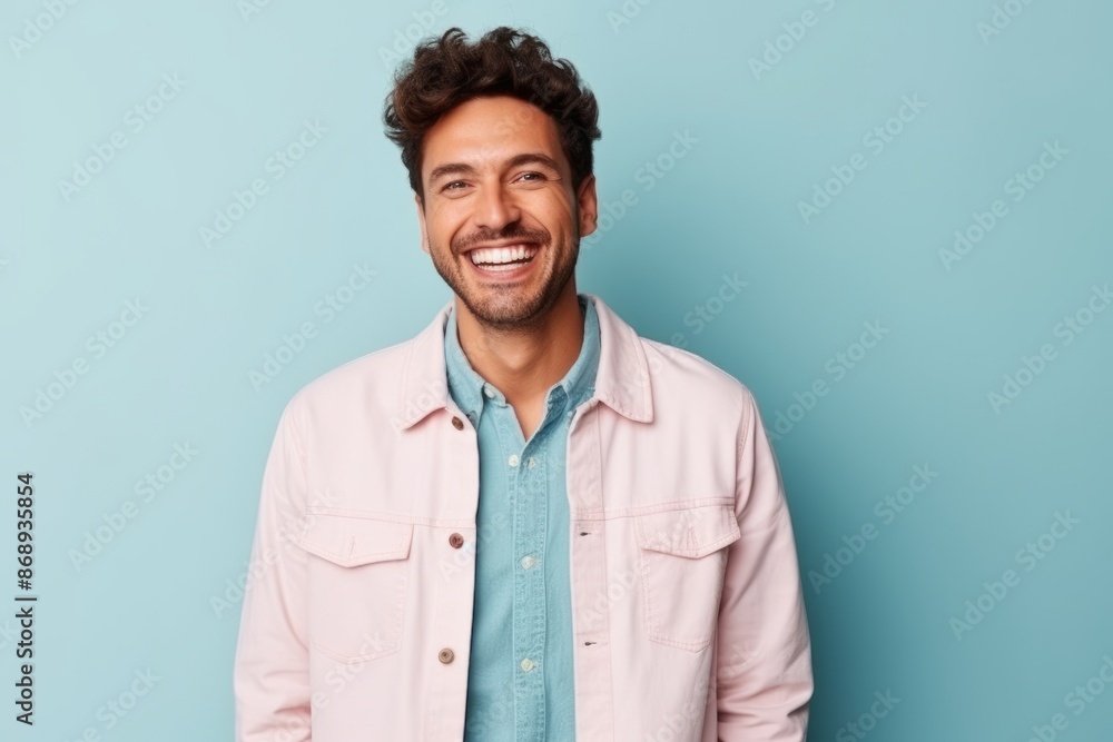 Portrait of a handsome young man laughing and looking at camera over blue background Portrait of a handsome young man laughing and looking at camera over blue background