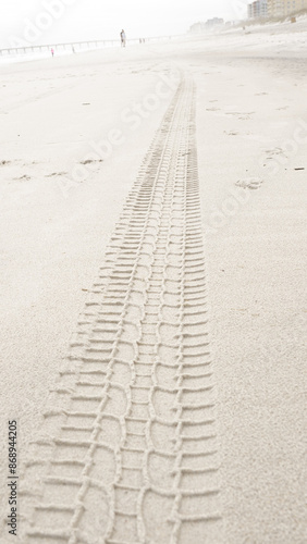 Detailed View of a Tire Track Left on a Sandy Beach Shoreline, Nature Transportation Adventure Scene photo