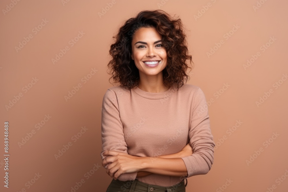 Obraz premium Portrait of a beautiful young woman with curly hair on a brown background
