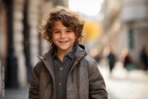 Portrait of a cute little boy smiling at the camera in the city