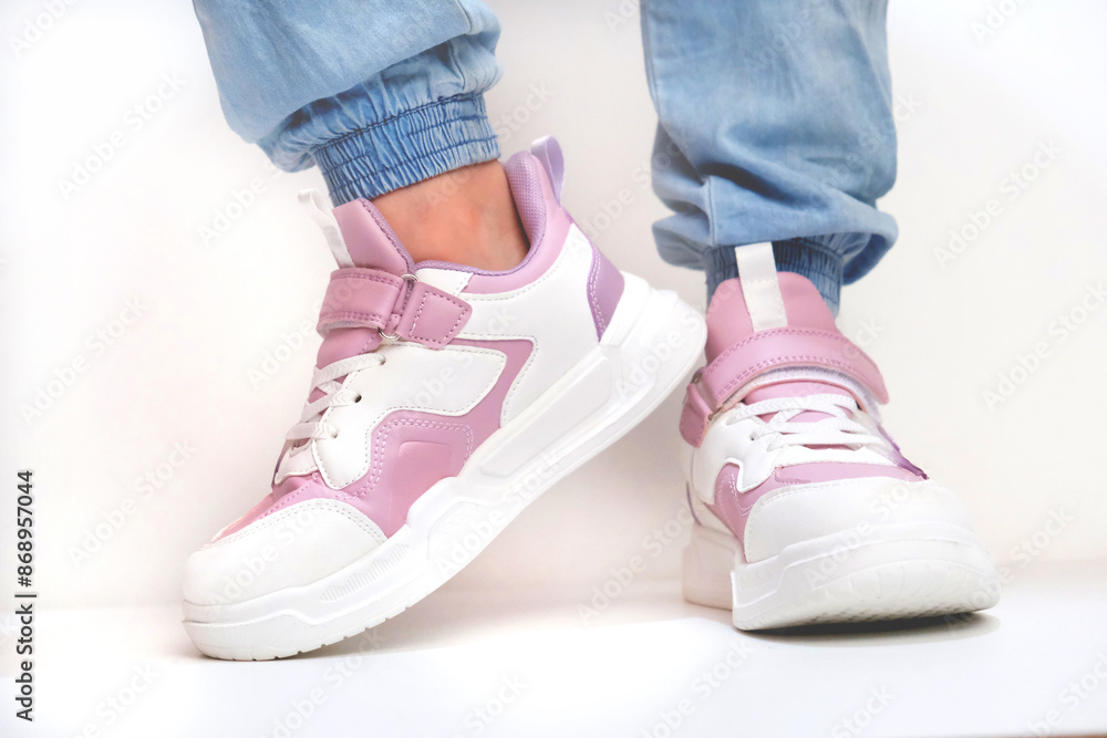 Girl with pink purple sneakers and blue jeans on a white background. Dancing Girl with pink purple sneakers and blue jeans on a white background. Dancing