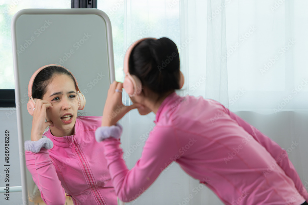 A girl ballet student in pink tracksuit, Warm up body by gently dancing to your favorite music through headphones A girl ballet student in pink tracksuit, Warm up body by gently dancing to your favorite music through headphones