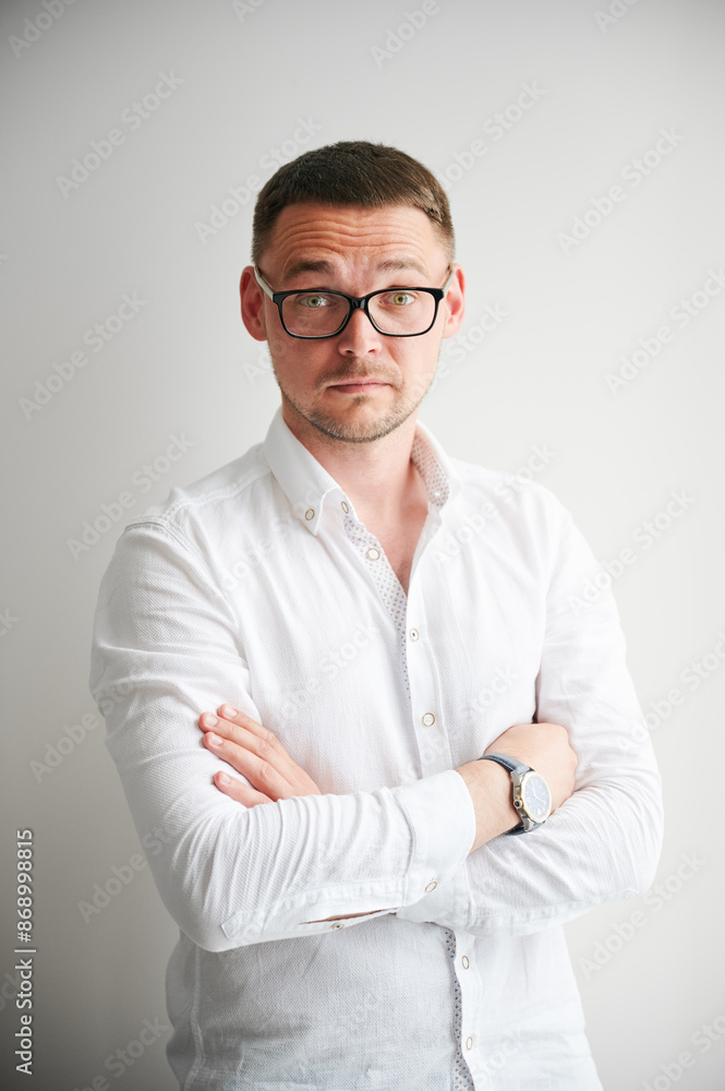 Portrait of man with raised eyebrows, which may suggest curiosity surprised or questioning attitude on his face. Handsome man in casual clothes keeping arms crossed while standing on white background. Portrait of man with raised eyebrows, which may suggest curiosity surprised or questioning attitude on his face. Handsome man in casual clothes keeping arms crossed while standing on white background.