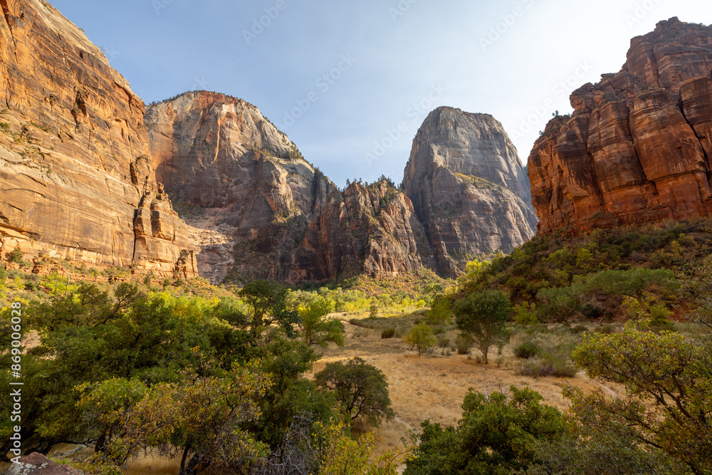 A breathtaking view of the majestic rock formations in Zion National Park, Utah. Lush greenery contrasts with the towering cliffs under a clear blue sky, showcasing the park's natural beauty. A breathtaking view of the majestic rock formations in Zion National Park, Utah. Lush greenery contrasts with the towering cliffs under a clear blue sky, showcasing the park's natural beauty.