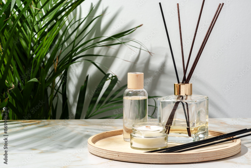 Black Reed Diffuser, Amber Candle, and Wooden Tray on White Surface Black Reed Diffuser, Amber Candle, and Wooden Tray on White Surface