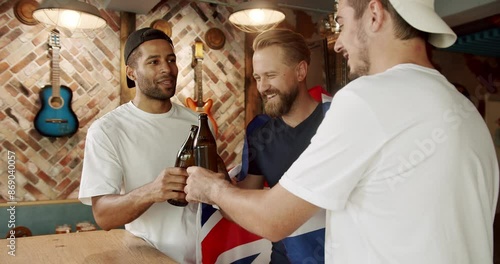 Happy mixed race supporters cheering and exulting after winning.Friends at the bar in a pub having fun. Men with the flag of the national country of Great Britain drinking beer and watching sport game photo