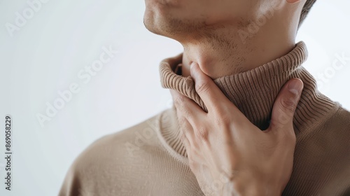 A man with a sore throat. touching their neck and looking uncomfortable. on white background. with white space photo