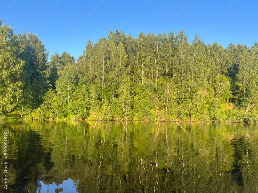 beautiful lake on the shore forest with reflection in water blue sky in reflection of water. beautiful lake on the shore forest with reflection in water blue sky in reflection of water.