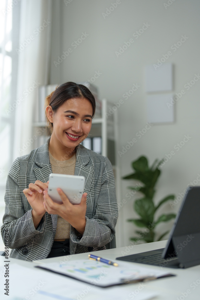 Young Asian businesswoman uses a calculator to calculate business principles. Accounting statistical concepts at the office starting a financial business, calculating accounting online marketing. Young Asian businesswoman uses a calculator to calculate business principles. Accounting statistical concepts at the office starting a financial business, calculating accounting online marketing.