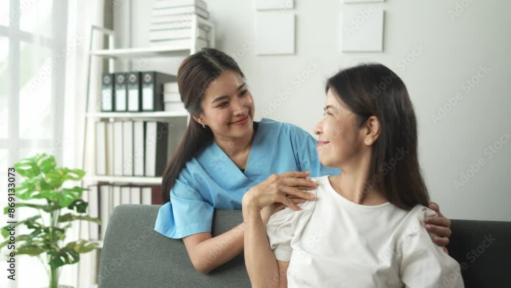 Female caregiver supports senior woman with shoulder exercise at home, sharing a positive interaction in a comforting environment Female caregiver supports senior woman with shoulder exercise at home, sharing a positive interaction in a comforting environment