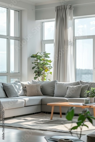 Interior of a bright living room with cozy gray sofas near a large window. 