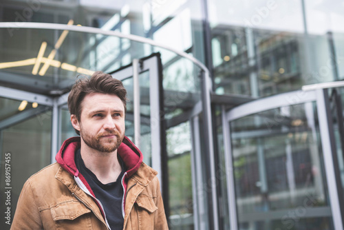 Wallpaper Mural Contemplative man in brown jacket near public building Torontodigital.ca