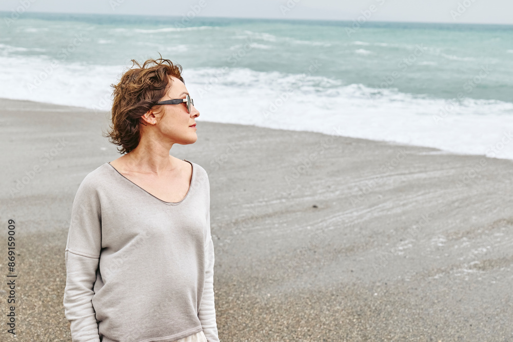 Beautiful woman looking at waves near coastline Beautiful woman looking at waves near coastline