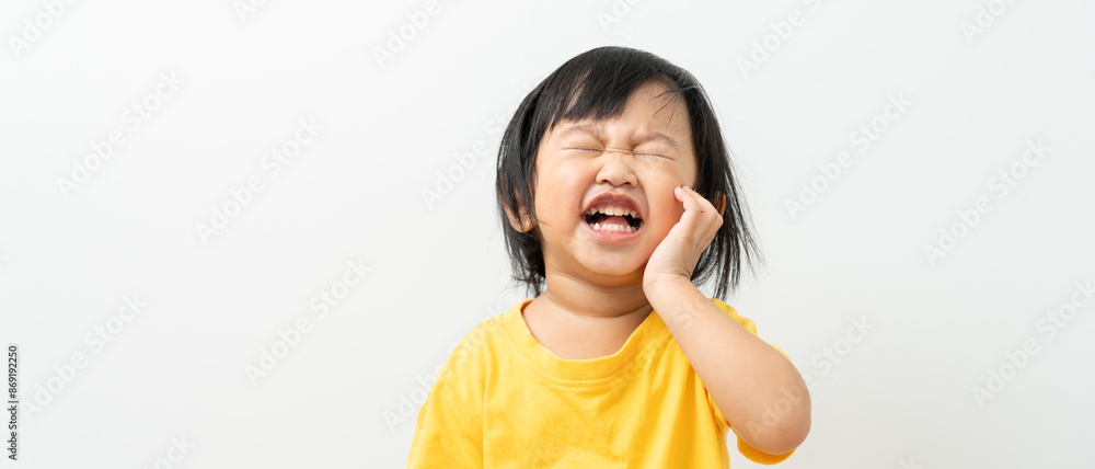 little asian girl presses hand to cheek, suffers from pain in tooth. Teeth decay, dental problems, child emotions and facial expression, oral health care, reducing sweets, fluorine coating little asian girl presses hand to cheek, suffers from pain in tooth. Teeth decay, dental problems, child emotions and facial expression, oral health care, reducing sweets, fluorine coating