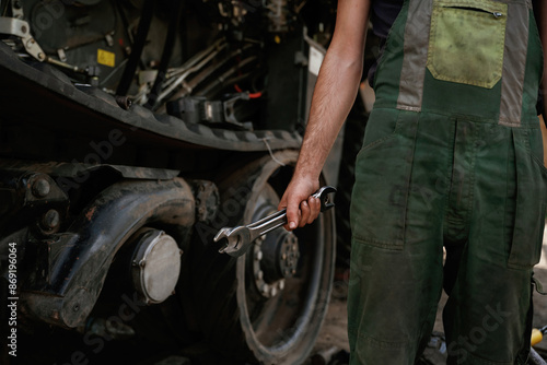 Holding wrench. Mechanic's hand fixing machinery in workshop © standret