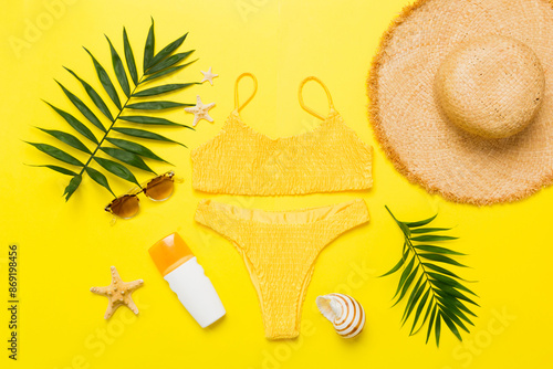 Woman swimwear and beach accessories flat lay top view. Top view with bikini outfit on color background. Vacation concept copy space photo
