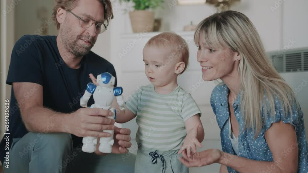 Mother and father playing giving baby a toy robot to play with Mother and father playing giving baby a toy robot to play with