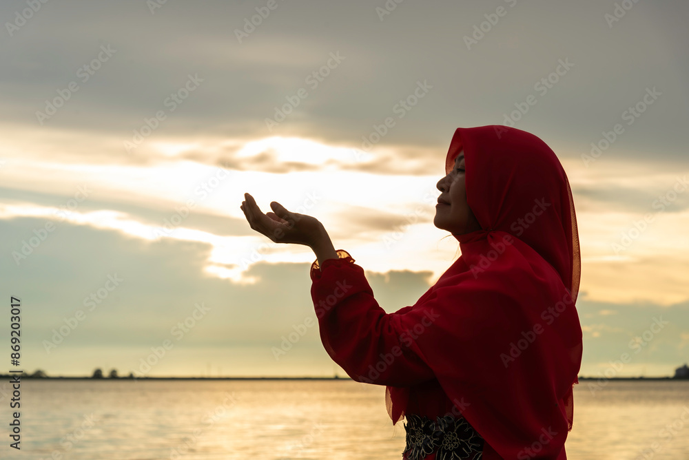 Fototapeta premium beautiful muslim woman praying outdoors at sunset